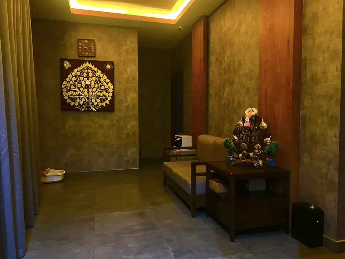 Reception and waiting lounge at Next Balance Spa with a gilded Bodhi tree artwork and seating